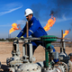 A worker operates valves in Nihran Bin Omar field north of Basra, Iraq.